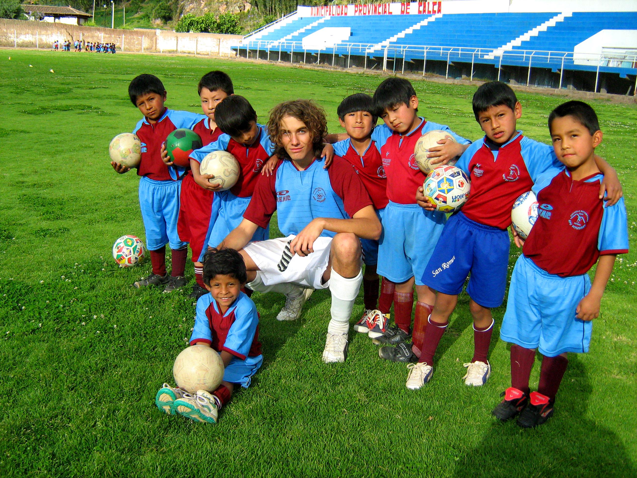 A Projects Abroad volunteer works as a sports coach in Peru running football lessons A sports instructor works with children during his volunteer sports coaching in Peru
